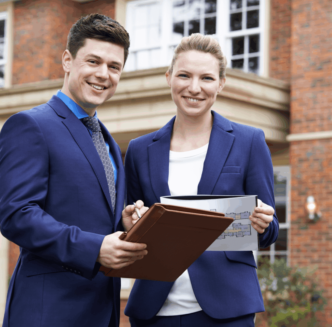 Two professionals smiling with documents outside a building.