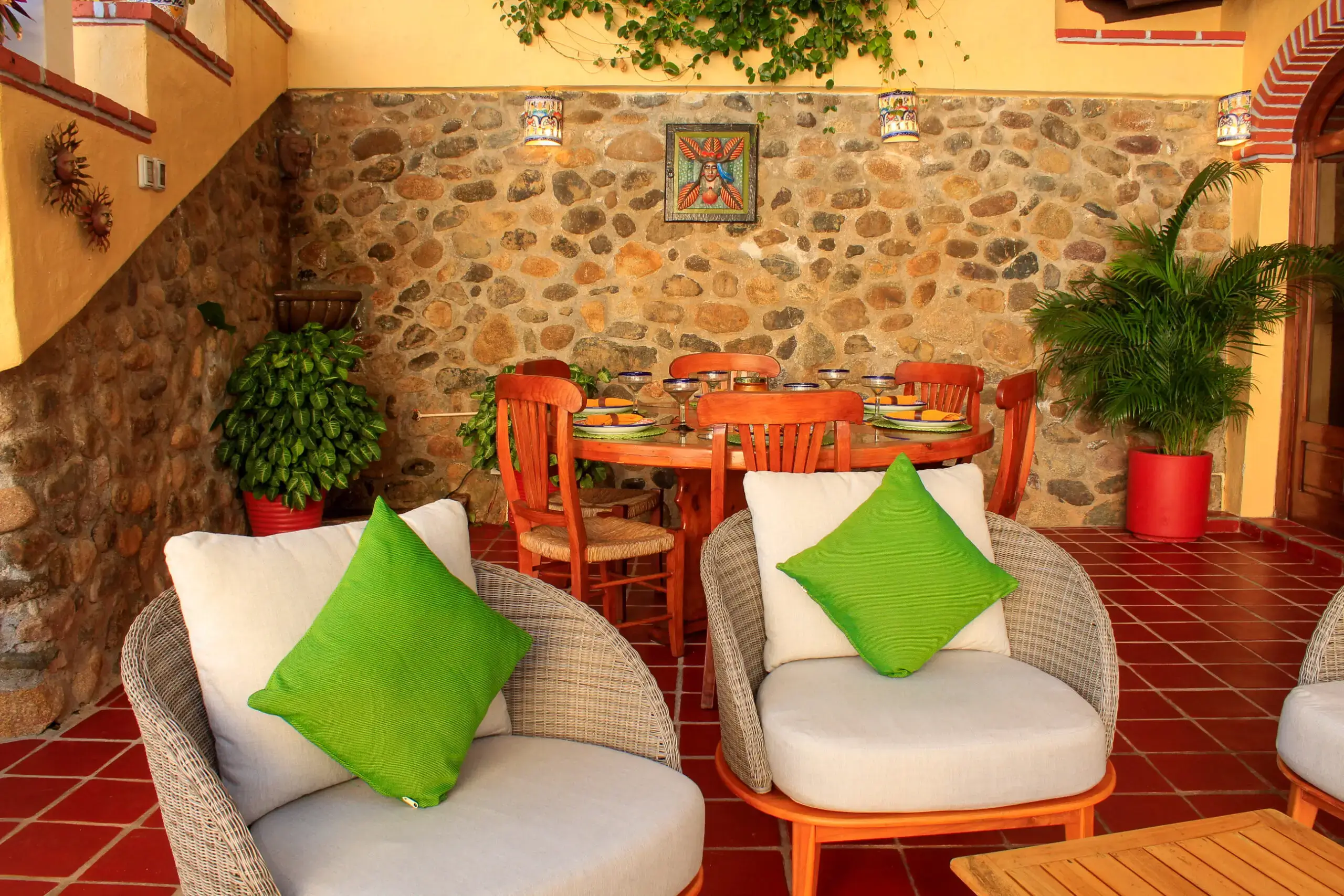 Cozy outdoor seating area with white chairs and green cushions.