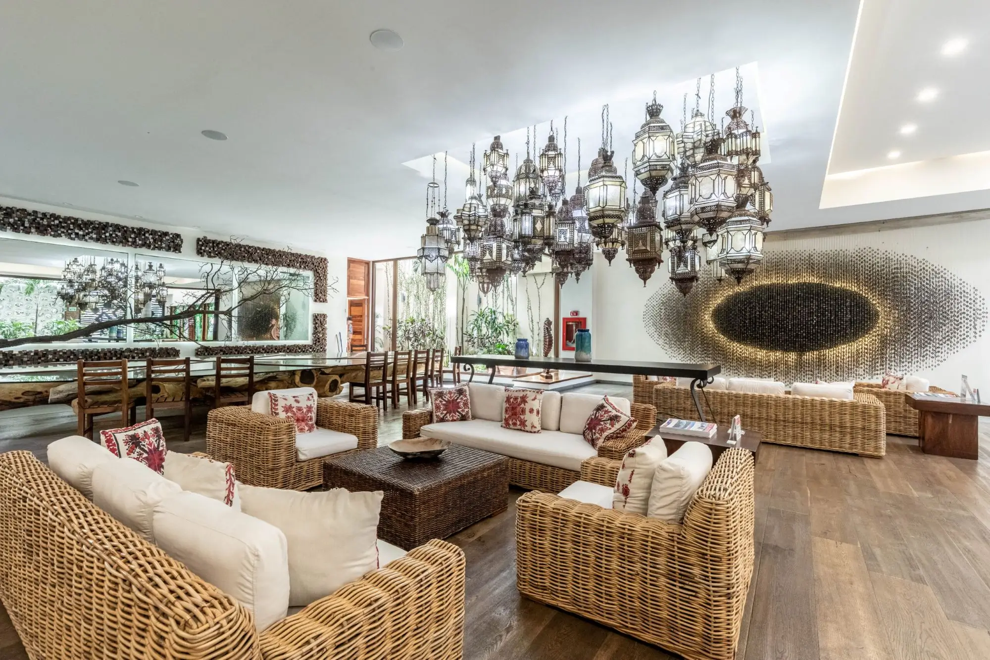 Elegant living room with wicker furniture and modern chandeliers.